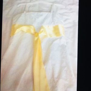 A white dress with a yellow silk ribbon.